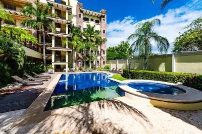 a swimming pool in front of a building at Beachfront Oceanview Private Jacuzzi & Full ktcn in Tamarindo