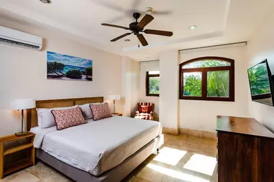 a bedroom with a bed and a ceiling fan at Beachfront Oceanview Private Jacuzzi & Full ktcn in Tamarindo