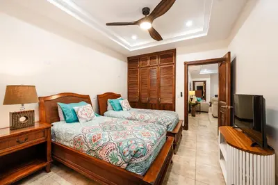 a bedroom with a bed and a flat screen tv at Beachfront Easy Beach access, security & cameras in Tamarindo