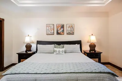 a bedroom with a large bed with two lamps at Beachfront Easy Beach access, security & cameras in Tamarindo