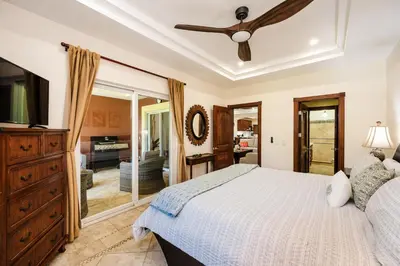 a bedroom with a bed and a ceiling fan at Beachfront Easy Beach access, security & cameras in Tamarindo