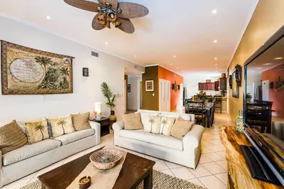 a living room with two couches and a ceiling fan at Amazing Condo Across the Street from the Beach in Tamarindo