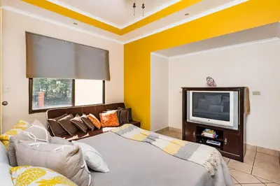 a living room with a couch and a tv at Amazing Condo Across the Street from the Beach in Tamarindo