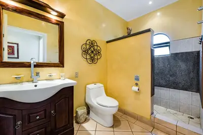 a bathroom with a toilet and a sink and a shower at Amazing Condo Across the Street from the Beach in Tamarindo