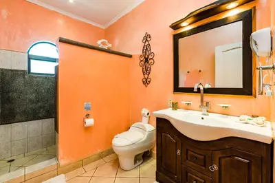 a bathroom with a sink and a toilet and a mirror at Amazing Condo Across the Street from the Beach in Tamarindo