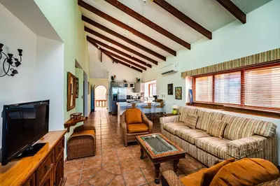 a living room with a couch and a tv at Beachfront Ocean view terrace right on the beach in Tamarindo