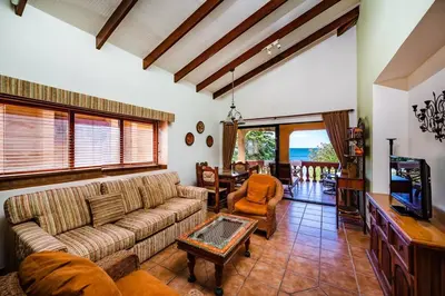 a living room with a couch and a tv at Beachfront Ocean view terrace right on the beach in Tamarindo