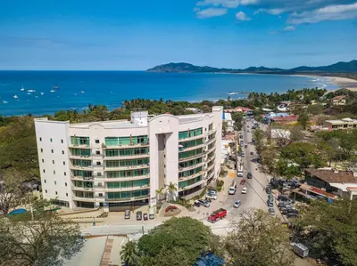 an aerial view of a large white building next to the ocean at Pura vida charm, canopy views, block from beach in Tamarindo