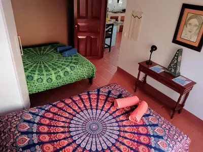 a room with two beds and a table with an umbrella at Casa Amapola in La Cruz