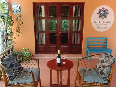 a table with a bottle of wine and two chairs at Casa Amapola in La Cruz