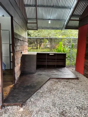 an outdoor room with a stone wall and a bench at Cabañas MOHES ballena in Uvita