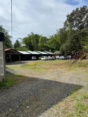 a building with cars parked in a parking lot at Cabañas MOHES ballena in Uvita