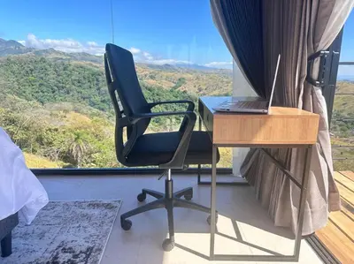 a bedroom with a desk and a laptop on a table at GoldenView+ Aire acondicionado+Jacuzzi (a 15 km de Monteverde) in Monteverde Costa Rica