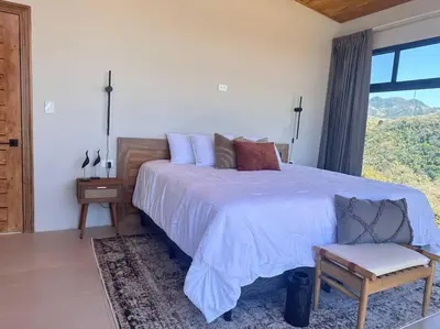 a bedroom with a large bed and a window at GoldenView+ Aire acondicionado+Jacuzzi (a 15 km de Monteverde) in Monteverde Costa Rica
