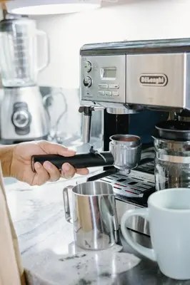 a person is using a coffee machine in a kitchen at Rocka Verde Retreat 8th Wonder of the World in Rivas