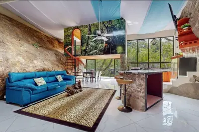a living room with a blue couch and a stone wall at Rocka Verde Retreat 8th Wonder of the World in Rivas