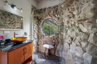 a stone bathroom with a sink and a stone wall at Rocka Verde Retreat 8th Wonder of the World in Rivas