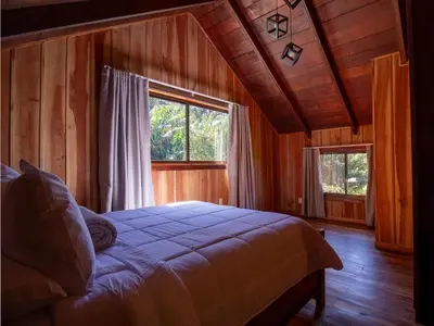 a bedroom with a bed and a large window at Mountain Wonders Chalet in Monteverde Costa Rica