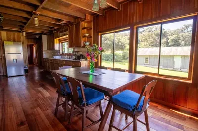 a large kitchen with a wooden table and chairs at Mountain Wonders Chalet in Monteverde Costa Rica