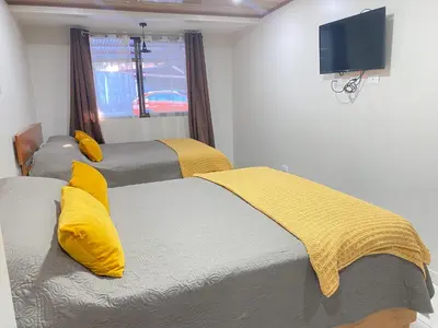 two beds with yellow pillows in a room with a window at Apartamentos H Gonzalez. Wifi A/C free parking in San Rafael