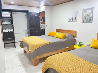 two beds in a room with yellow and gray at Apartamentos H Gonzalez. Wifi A/C free parking in San Rafael