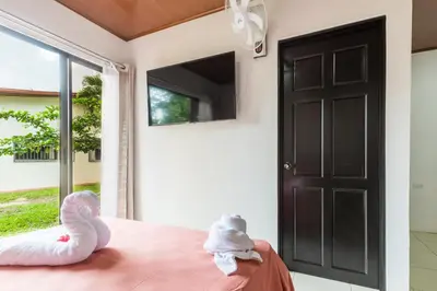 a bedroom with a black door and two stuffed animals on a bed at Rio Celeste Birds Garden Apartment, Aire Acondicionado, comodidad y privacidad en un entorno natural 2 in Upala
