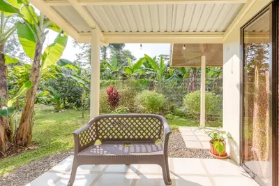 a bench on a patio with a view of a garden at Rio Celeste Birds Garden Apartment, Aire Acondicionado, comodidad y privacidad en un entorno natural 2 in Upala