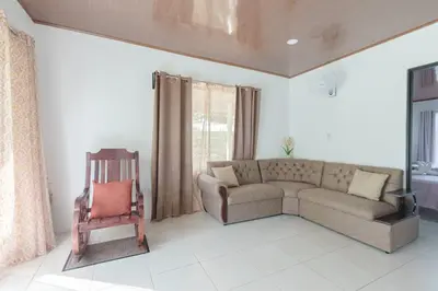 a living room with a couch and a chair at Rio Celeste Birds Garden Apartment, Aire Acondicionado, comodidad y privacidad en un entorno natural 2 in Upala