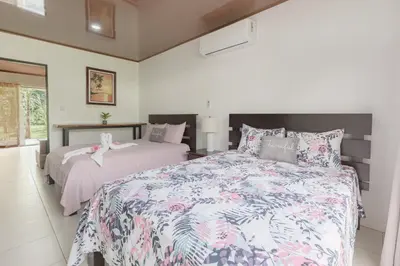 a bedroom with two beds and a window at Rio Celeste Birds Garden Apartment, Aire Acondicionado, comodidad y privacidad en un entorno natural 2 in Upala
