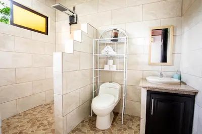 a bathroom with a toilet and a sink at Rio Celeste Birds Garden Apartment, Aire Acondicionado, comodidad y privacidad en un entorno natural 2 in Upala