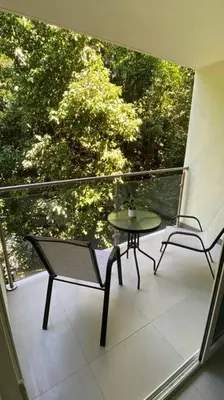 a balcony with a table and a chair on a porch at Apartamento hermoso Playa Mantas in Punta Leona