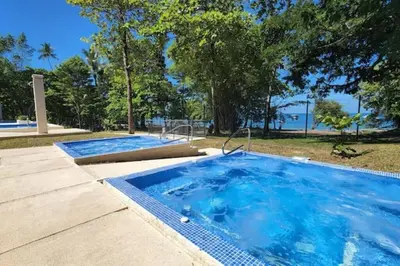 a large swimming pool with blue water in a park at Apartamento hermoso Playa Mantas in Punta Leona