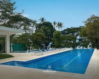 a large swimming pool with lounge chairs and trees at Apartamento hermoso Playa Mantas in Punta Leona