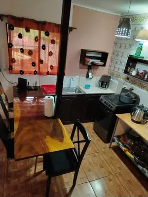 a kitchen with a wooden table and a stove at La Martha in Sarapiquí