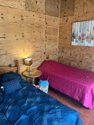 a bedroom with two beds and a table with a lamp at Casa D'Pa in San Gerardo de Dota