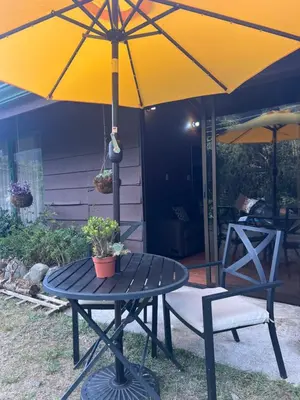 a patio table with a yellow umbrella and two chairs at Casa D'Pa in San Gerardo de Dota