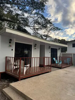a home with a porch with chairs on it at Macaw Paradise in Jacó