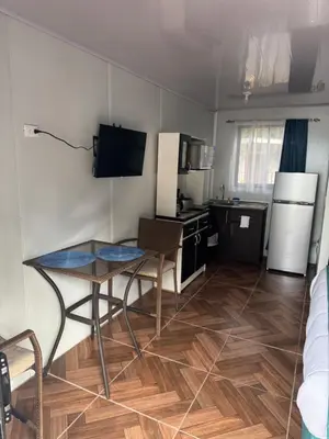 a small kitchen with a table and a kitchen with a refrigerator at Macaw Paradise in Jacó