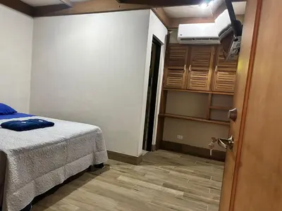 a small bedroom with a bed and a closet at Macaw Paradise in Jacó