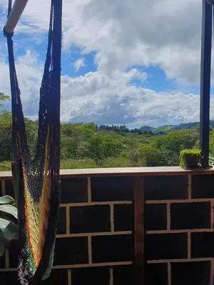 a bag hanging on a fence with a view of a field at El Chagüite monteverde #2 in Monteverde Costa Rica