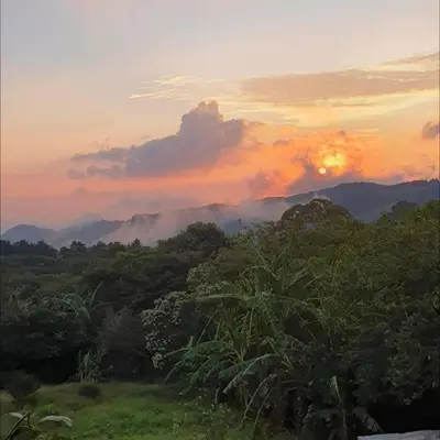 a sunset in the mountains with trees and clouds at El Chagüite monteverde #2 in Monteverde Costa Rica