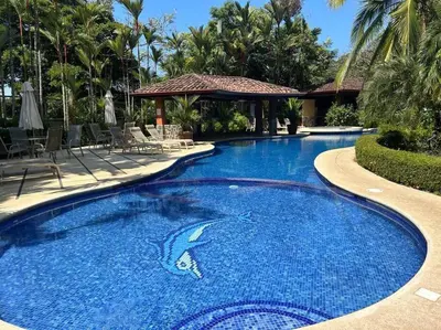a swimming pool in a resort with a shark in the water at Villa Ela en Playa Herradura in Herradura