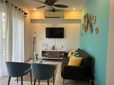 a living room with a couch and a tv at Villa Ela en Playa Herradura in Herradura