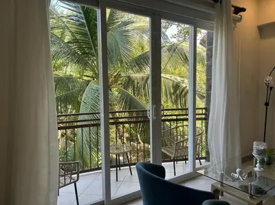 a room with a large window with a view of a palm tree at Villa Ela en Playa Herradura in Herradura