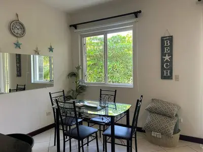 a dining room with a table and chairs and a window at Villa Ela en Playa Herradura in Herradura