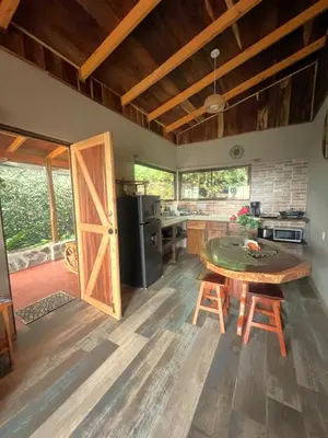 a kitchen with a table and chairs and a door at Casa Típica La Cruz in Monteverde Costa Rica