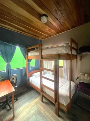 two bunk beds in a room with a desk at Casa Típica La Cruz in Monteverde Costa Rica