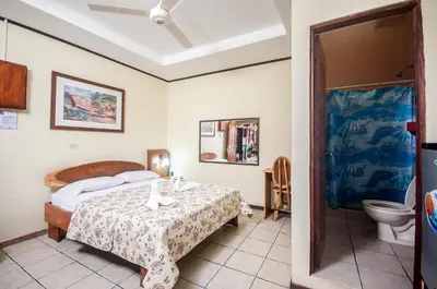 a bedroom with a bed and a toilet at Cadillac Rock Beach Hotel in Jacó