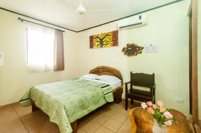 a bedroom with a bed and a chair at Cadillac Rock Beach Hotel in Jacó