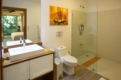a bathroom with a toilet and a sink and a shower at La Vela Boutique Hotel in Manuel Antonio